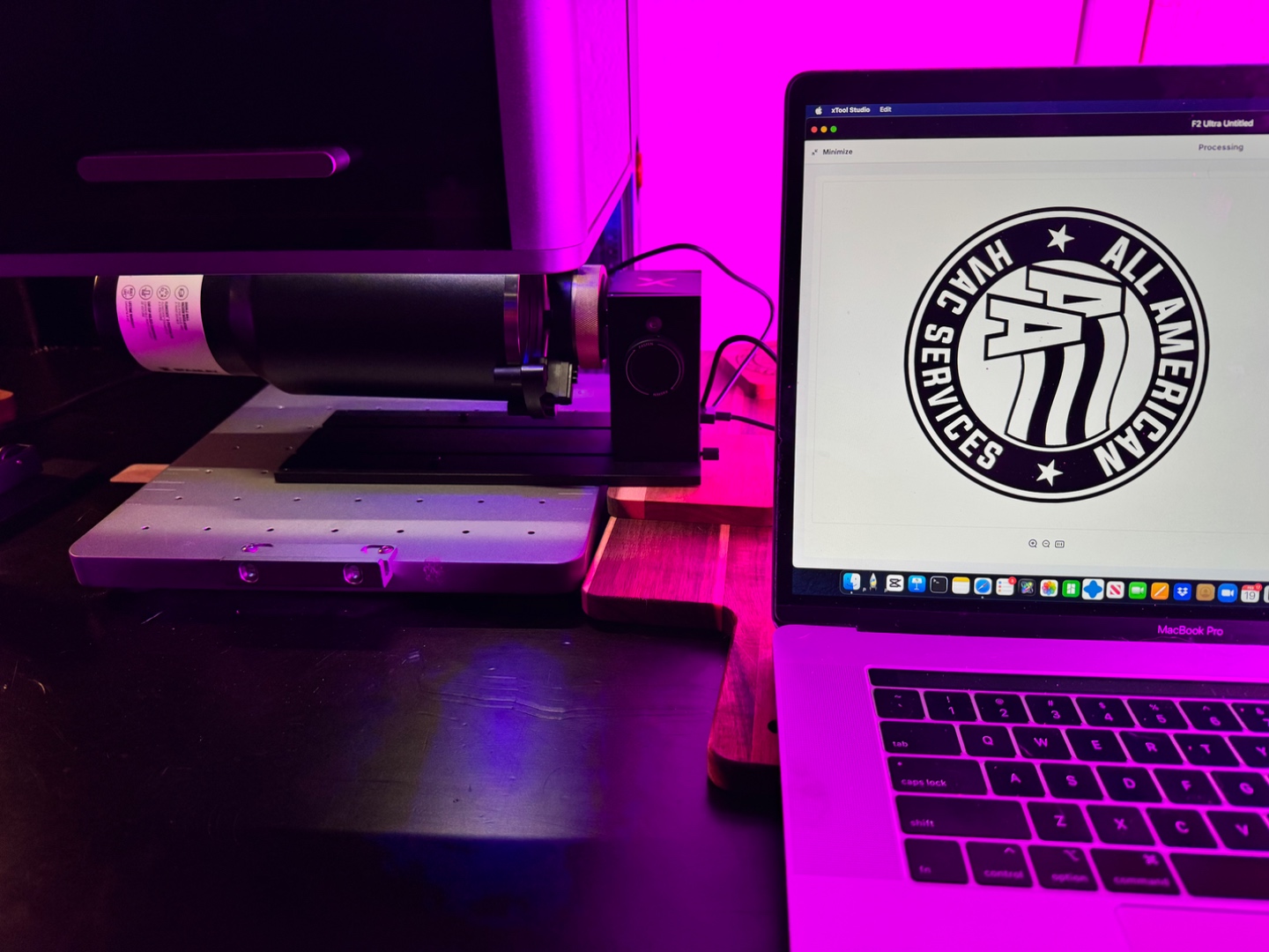 Laptop and xTool machine with warm pink ambient light