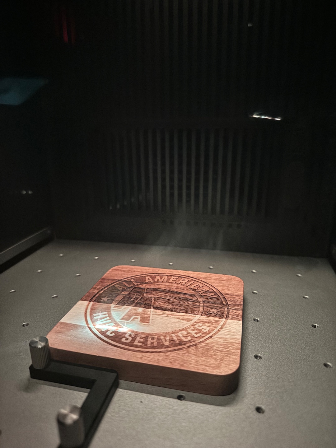 Active laser engraving — smoke rising as the xTool F2 Ultra cuts into wood